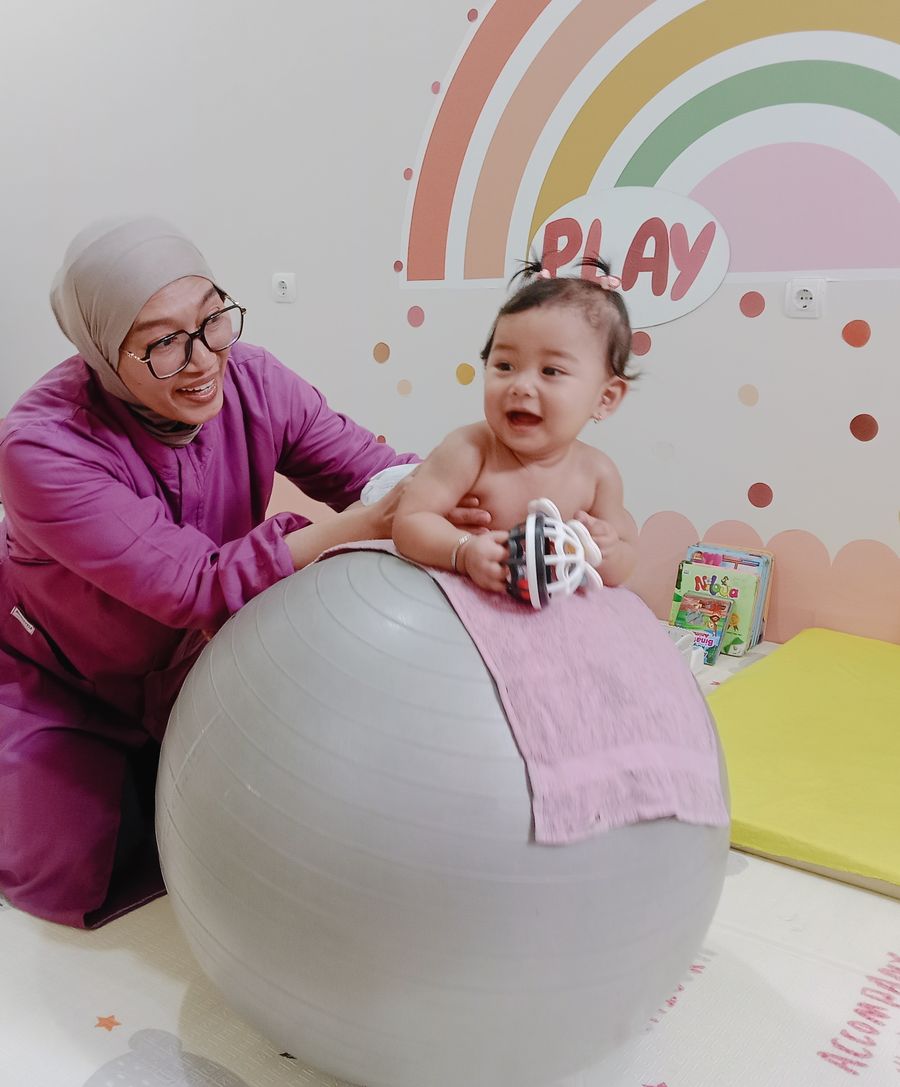 Bidan mendampingi bayi di atas bola